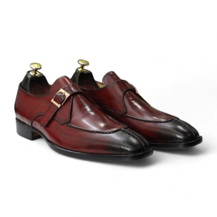 Handmade men's burgundy Oxford dress shoes, featuring a premium leather upper, a split-toe design, and a single buckle monk strap, displayed on a sleek leather sole